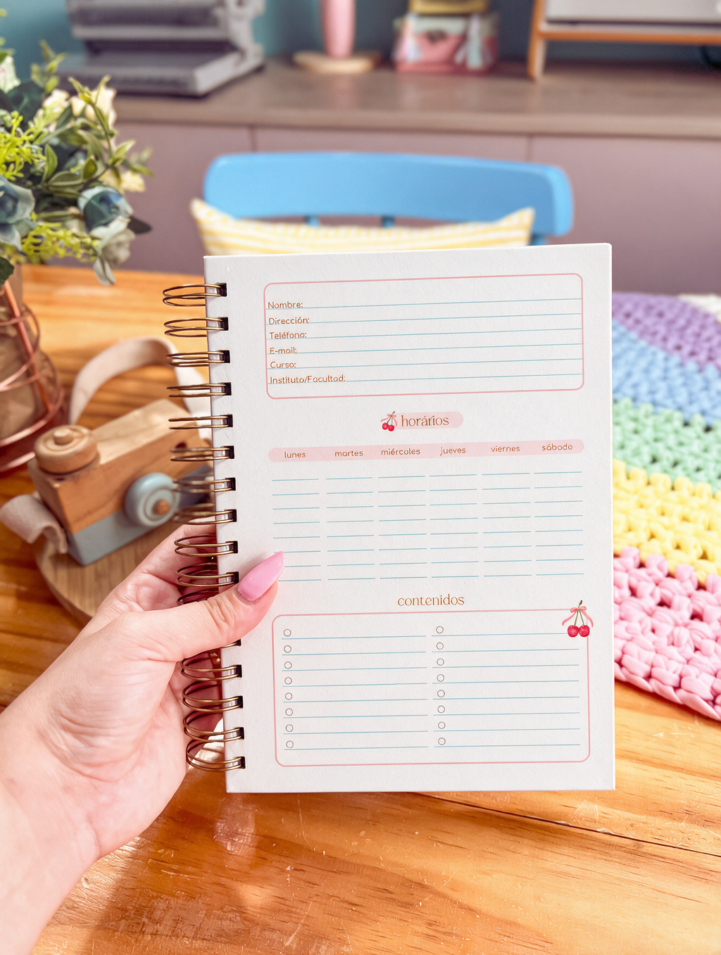 Libreta bonita de anillas abierta por la página de datos personales, horario semanal de lunes a sábado y lista de contenidos, con cerezas con lazo
